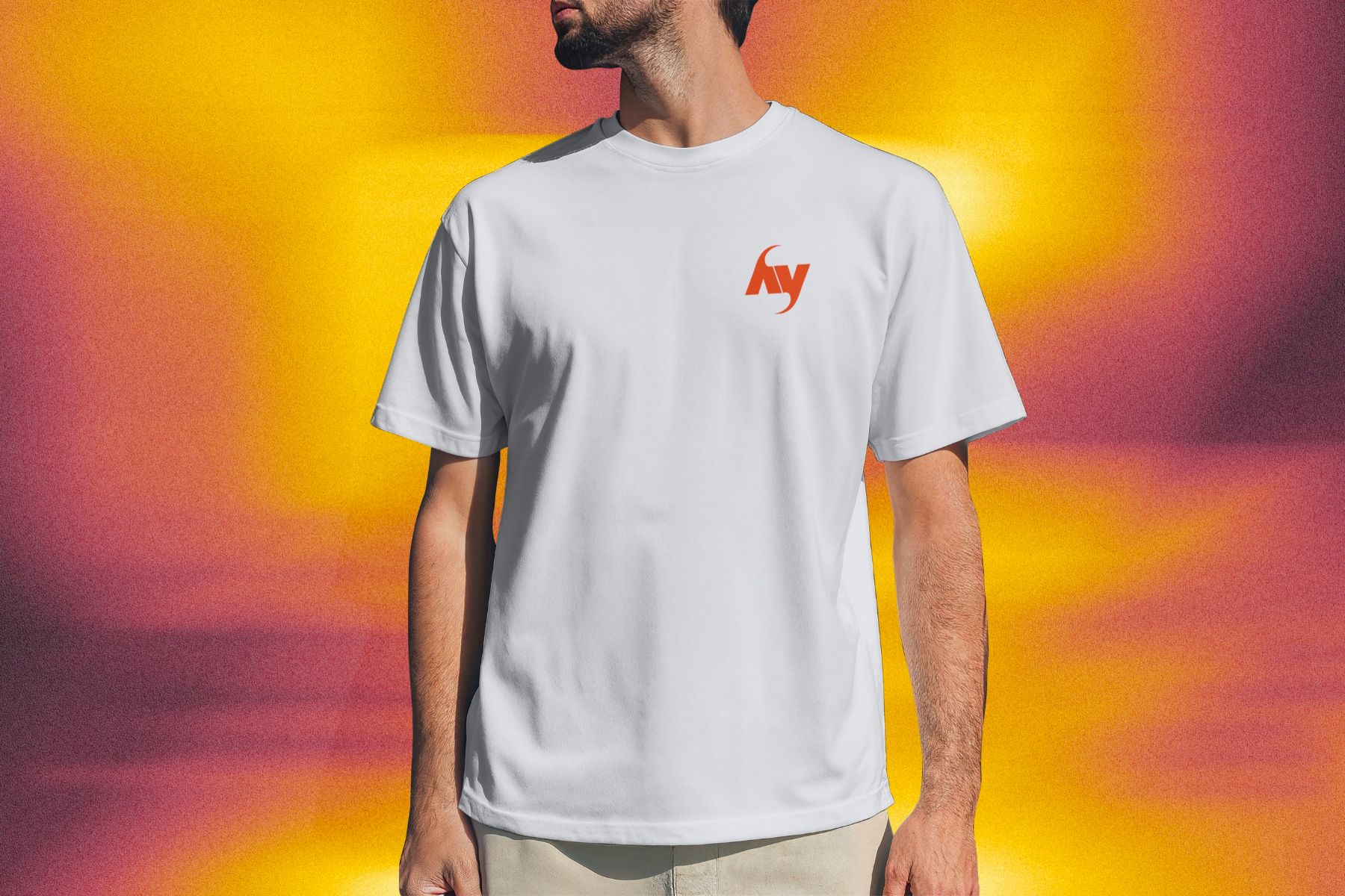 Un homme en t-shirt blanc au monogramme hy orange, devant un fond orange et violet